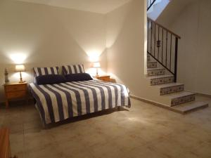 a bedroom with a bed with two lamps and a staircase at Rascasa 2/5 in La Mata
