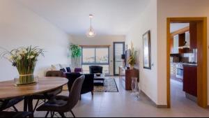 a living room and kitchen with a table and chairs at Parque Atlântico com Vista Mar in Quarteira