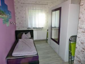 mały pokój z łóżkiem i oknem w obiekcie Ferienwohnung Baacke w mieście Ruhla