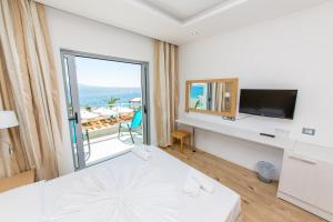 a hotel room with a bed and a large window at Hotel Saranda Palace in Sarandë