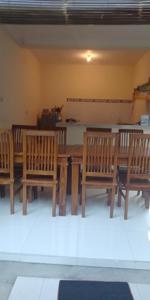 a dining room with a table and four wooden chairs at Pondok Aldi in Amed