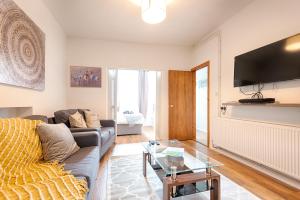 a living room with a couch and a table at Generous House near The Liberty Stadium in Swansea