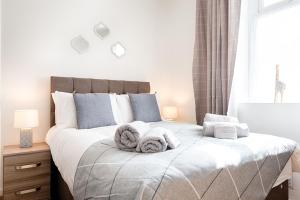 sypialnia z łóżkiem z ręcznikami w obiekcie Generous House near The Liberty Stadium w mieście Swansea