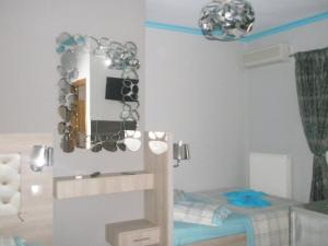 Habitación pequeña con cama y espejo. en Blue Dream Hotel, en Olympiakí Aktí