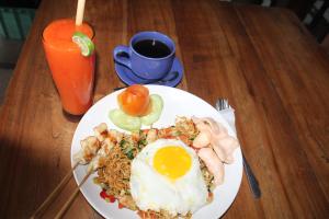 un piatto di cibo con un uovo e tagliatelle su un tavolo di Bali Villa coral ad Amed Altre 44 foto