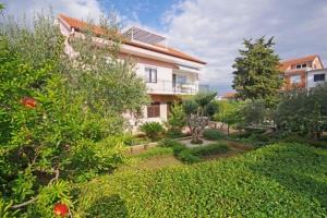 a large house with a garden in front of it at Marija Apartments in Pirovac