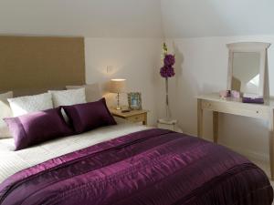 a bedroom with a bed with a purple blanket at Berkshire Rooms Ltd - Gray Place in Bracknell