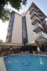un hotel con piscina frente a un edificio en Kleopatra Micador Otel en Alanya