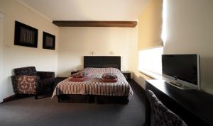a bedroom with a bed and a flat screen tv at Hotel Kasteel Doenrade in Doenrade
