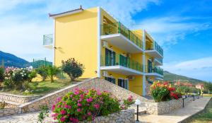 斯卡拉克弗隆尼亞斯的住宿－夏日陽光公寓，前面有鲜花的黄色建筑