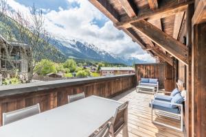夏蒙尼-勃朗峰Apt. Grand Paradis B14 - Modern with Mont Blanc view的阳台配有桌椅,享有山景。