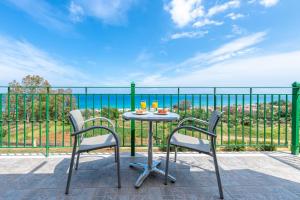 a table and chairs on a balcony with a view of the ocean at Summer Sun in Skala