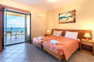 a bedroom with a bed and a balcony at Summer Sun in Skala Kefalonias