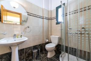 a bathroom with a toilet and a sink and a shower at Summer Sun in Skala
