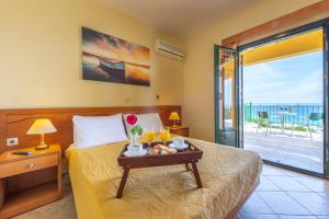 a bedroom with a bed with a tray of food on it at Summer Sun in Skala