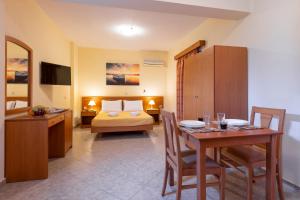 a hotel room with a bed and a table and a room at Summer Sun in Skala