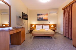 a hotel room with a bed and a television at Summer Sun in Skala