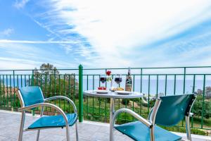 a table and chairs on a balcony with a view of the ocean at Summer Sun in Skala