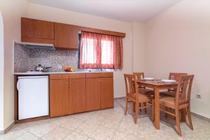 a kitchen with a table and a table and chairs at Summer Sun in Skala