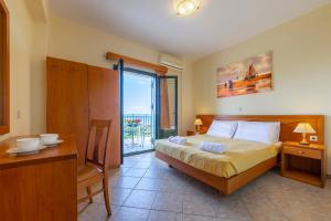 a bedroom with a bed and a table and a window at Summer Sun in Skala