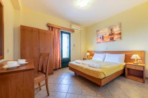 a bedroom with a bed and a table and a desk at Summer Sun in Skala