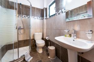 a bathroom with a sink and a toilet and a shower at Summer Sun in Skala