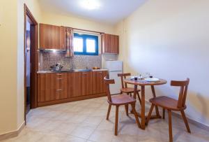une cuisine avec une table, des chaises et un évier dans l'établissement Summer Sun, à Skála Kefalonias