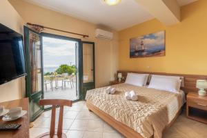 a bedroom with a large bed and a balcony at Summer Sun in Skala