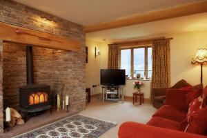 a living room with a fireplace and a tv at The Celyn in Pont Newydd