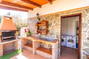 uma cozinha com um lavatório e uma parede de pedra em Cubo's Casa La Dehesilla High Privacy and Pool em Alhaurín el Grande
