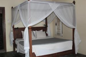 una camera da letto con letto a baldacchino con tende bianche di Bali Villa coral ad Amed