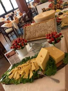 einen Tisch mit Käse, anderen Käse und Blumen in der Unterkunft Hotel Leonardo Da Vinci Wellness SPA in Bibione