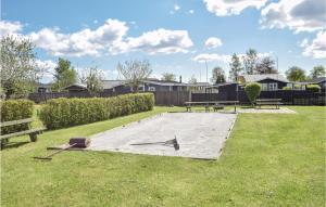 a park with picnic tables and benches in the grass at Three-Bedroom Holiday Home In Juelsminde in Sønderby
