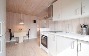 a kitchen with white cabinets and a wooden ceiling at Three-Bedroom Holiday Home In Juelsminde in Sønderby