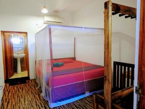 un letto a baldacchino in una stanza di Cresent Bay Beach Hotel ad Arugam