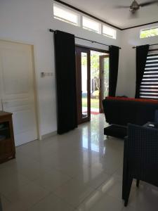 sala de estar con cortinas negras y sofá en Dream Estate Resort, en Senggigi 