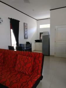 a living room with a red couch and a kitchen at Dream Estate Resort in Senggigi 