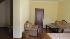 una habitación con 2 sillas, una mesa y una puerta en Hotel Central, en Jermuk