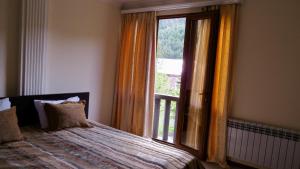 ein Schlafzimmer mit einem Bett und einem großen Fenster in der Unterkunft Centrale Guesthouse in Dschermuk