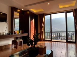 a living room with a large window with a view at Sapa Meriton Boutique Hotel in Sapa