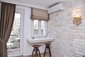 um quarto com dois bancos ao lado de uma parede de tijolos em Old Town Skyline apartment 3 em Budva