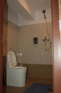a bathroom with a shower and a toilet with the lid up at Hotel Malla Inn in Bhaktapur