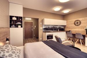 Cet appartement comprend une chambre avec un lit et une cuisine. dans l'établissement Trio Tatry, à Starý Smokovec