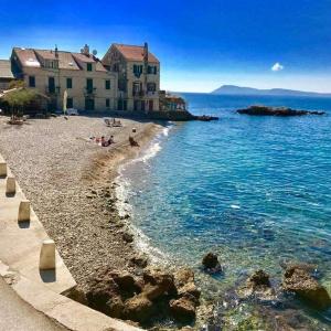 a beach with buildings and people on the water at Apartment Tina in Komiža