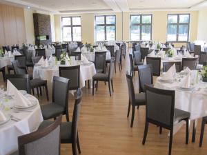 a banquet hall with white tables and chairs at Hotel-Gasthof-Hirsch in Dellmensingen