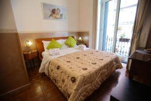 - une chambre avec un lit doté d'oreillers verts et d'une fenêtre dans l'établissement Benvenuto a Napoli, à Naples