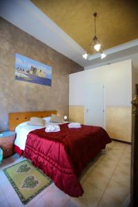 ナポリにあるBenvenuto a Napoliのベッドルーム1室(赤毛布付きの大型ベッド1台付)