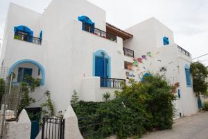 un edificio blanco con puertas y ventanas azules en Studios Zafiri en Naxos