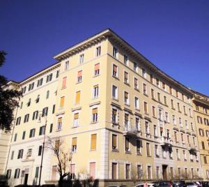 un grande edificio bianco con molte finestre di 500 Suite Prati delle Vittorie a Roma