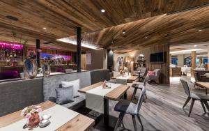 a restaurant with tables and chairs and a bar at Hotel Zirmerhof & Residence in Rifiano